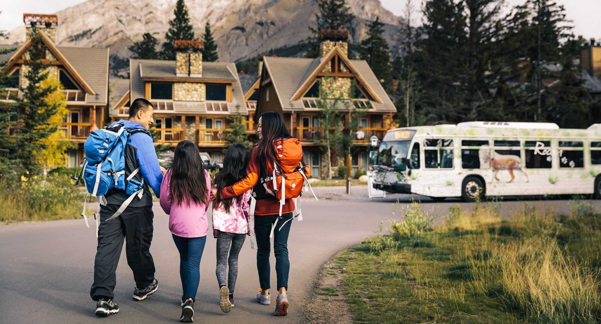 A family walking together to get on a Roam Transit Bus in Banff National Park
